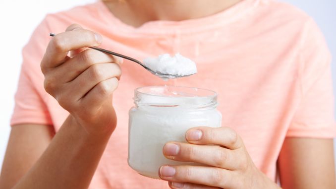 Woman With Spoonful Of Coconut Oil