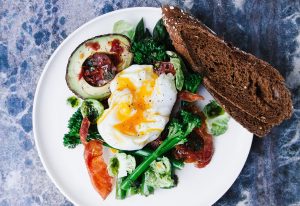 Healthy breakfast with greens, avocado and egg