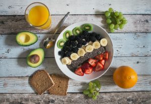 A sweet breakfast bowl with fruits, toast, juice and avocado