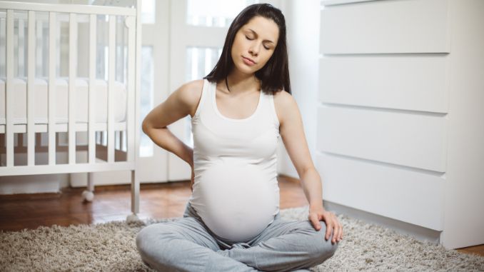Exhausted pregnant woman feeling lumber pain