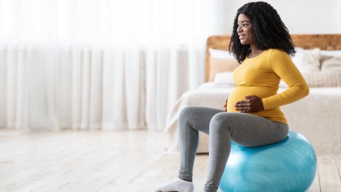 pregnant lady sitting on fitness ball