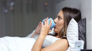 woman drinking coffee in bed